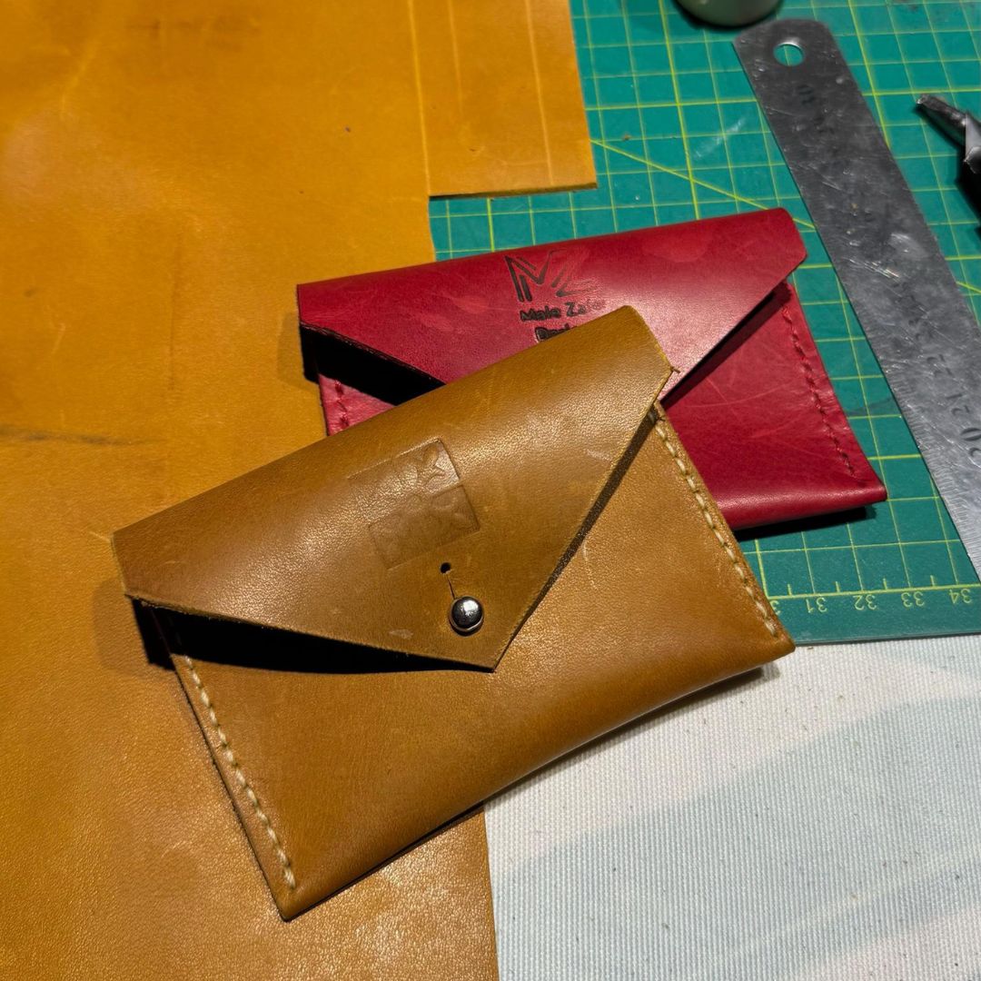 Brown leather wallet on a cutting mat with red wallet in the background